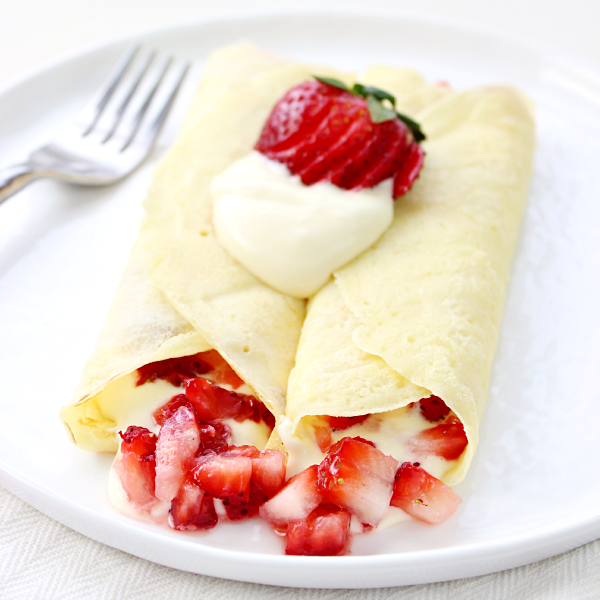 Strawberry & Lemon Cream Crepes on a plate with a fork.