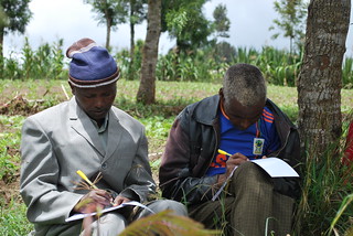 Gabriel Sikay (right) and a fellow farmer take notes during the on-farm training on forage data collection and soil water management (Photo credit: IITA/Gloriana Ndibalema)