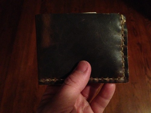 Since I had some leather, waxed thread of various sizes and a small canvas bag from a biscuit mix laying around, I made a wallet.