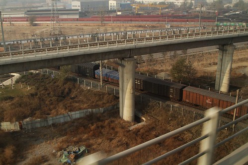 Freight train passes below our high-speed train