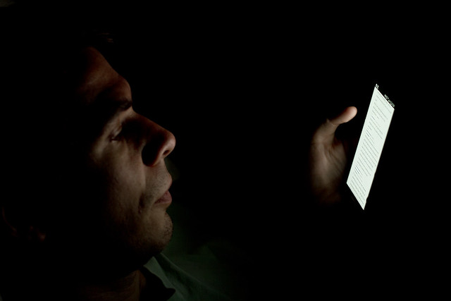 Person looking at smartphone in the dark