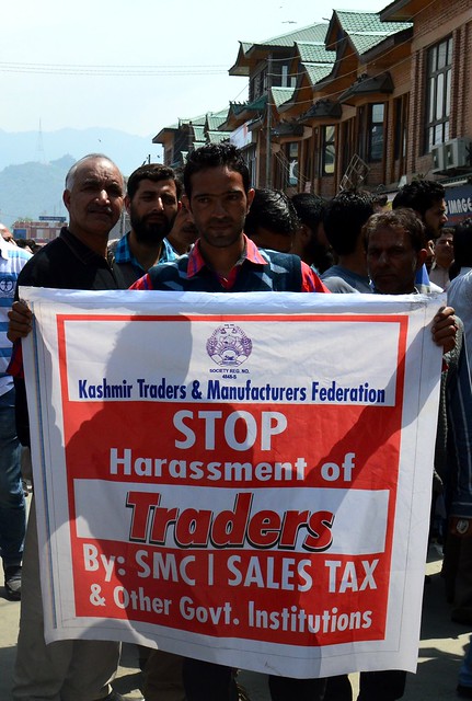 Trader displaying a banner pleading the government to take action against erring officials of Srinagar Municipal Corporation and Sales Tax who allegedly harass the traders frequently.